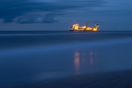 Night shot of a ship laying a submarine cable