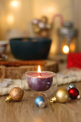 Various Christmas decorations, cup of tea or coffee, sweets, small presents, knitted blanket and candles. Selective focus.