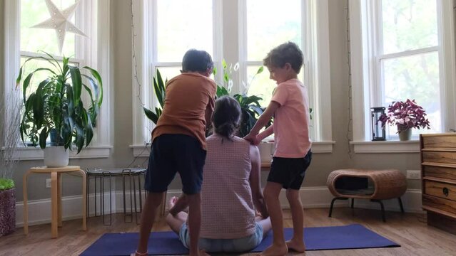 Two children sons brothers lifestyle bother their mother at home indoor meditation yoga fatigue overwork gender perspective single mom funny scene