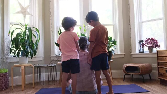 Two children sons brothers lifestyle bother their mother at home indoor meditation yoga fatigue overwork gender perspective single mom funny scene