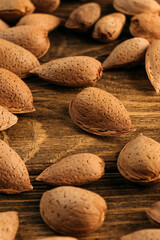 unpeeled almonds in a shell in a bowl, on a wooden table