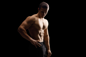 Fototapeta premium Topless young muscular man isolated on black