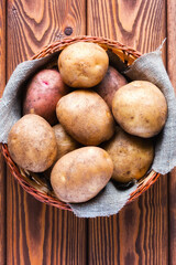 basket with potatoes on a wooden background