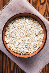 oat flakes in a bowl on a napkin and a wooden spoon