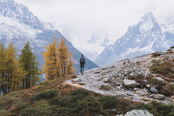 man hiking in het mountains with glaciers in background