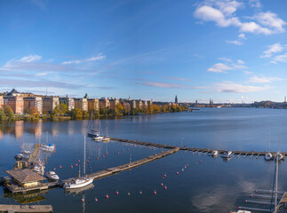 Empty summer boat piers, skyline of Town City Hall, Governmental Buildings, commuter boat, old town Gamla stan a sunny autumn in Stockholm