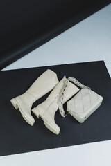 Women's leather boots on a plain background with a leather bag. New collection of women's winter shoes.