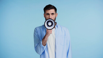 bearded man making announcement in loudspeaker isolated on blue