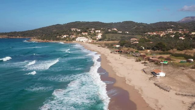 Pero beach of Cargese in Corsica on a sunny day. Drone aerial view of the Mediterranean Sea and sand beach with rocks at sunrise
