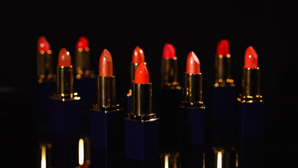 Close up view of bright red lipsticks on black background