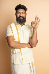 Happy South indian woman wearing traditional saree doing ok sign with fingers, smiling friendly gesturing excellent symbol.