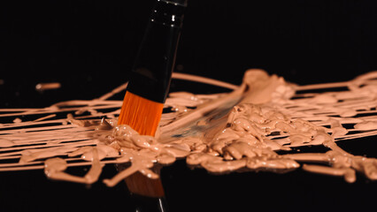 Close up view of cosmetic brush on makeup foundation on black background