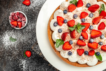 Delicious strawberry tart on dark background, top view