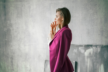 Young businesswoman. Beautiful woman director, head, general manager, ceo in astylish bright business pink, fuchsia color suit at photoshoot in armchair. Business purposeful ambitious girl careerist