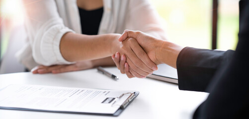 Attractive Asian business women shake hands after successful business deal, consensus business meeting.