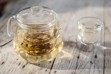 Set of jamine, mint and tea from glass tea pot. Focus on tea in the pot. Concept of aroma, atmosphere, freshness and relaxing warm drinks with copy spaces. English and Chinese traditional.