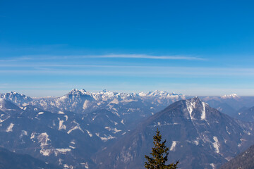 Obraz premium Scenic view on snow capped mountain peaks of Karawanks in Carinthia (Kaernten), Austria. Julian Alps. Winter wonderland in Austrian Alps, Europe. View from Freiberg on Hochstuhl (Stol), Triglav, Kepa