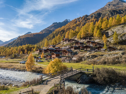Blatten, Switzerland - October 19. 2022: Alps village with tradtional wooden chalets in autumn on the larch forest hillside in Loetschental valley, Canton Valais