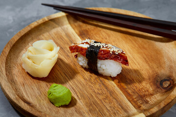 Sushi with smoked eel and sesame seeds on a black background. Japanese dish Unagi sushi.