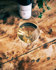 Bottle of wine and glass on wooden textured surface