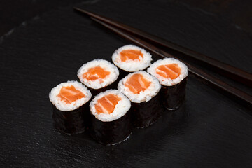 Set of tuna sushi rolls on black desk background