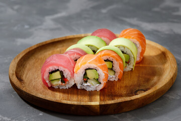 Top view background with set of colorful different kinds of sushi rolls placed on wooden board
