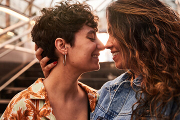 Glad lesbian couple hugging on stairs