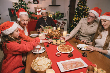 Merry Christmas! Happy family are having dinner at home. Celebration holiday and togetherness near tree