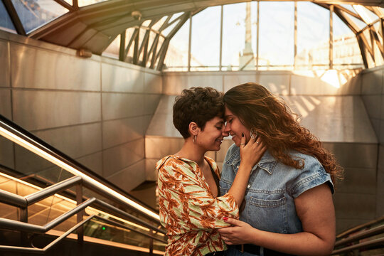 Glad lesbian couple hugging on stairs