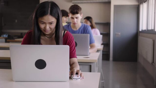 Large Group of Multi Ethnic smiling Students Working on the Laptops while Listening to Lecture in the Classroom. Young cheerful People Study University. Selective focus in the guy. High quality photo