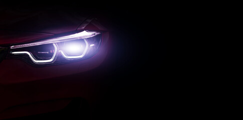Car headlights close up , banner. Light of car headlights on a dark background, panorama, copy space.