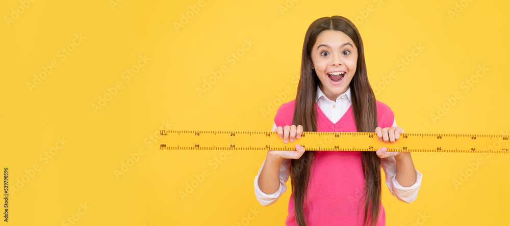 Wall mural surprised kid girl use ruler to learn mathematics, measurement. Banner of school girl student. Schoolgirl pupil portrait with copy space.