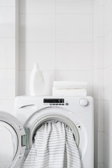 washer machine with dirty bedding in white bathroom