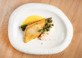 Fried fish fillet. Cod with sauce and herbs