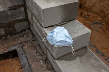 Bricklaying of foundation blocks. Building a new home, A construction worker is in quarantine due...