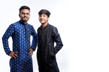 two Indian men wears ethnic or traditional cloths, Male fashion models with sherwani or Kurta Pyjama, standing and posing over white background, selective focus - obrazy, fototapety, plakaty