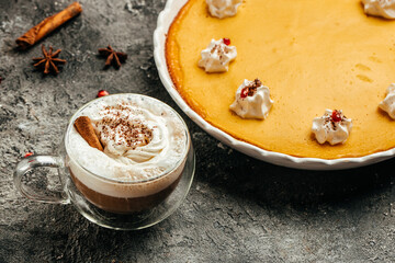 Homemade pumpkin pie cheesecake decorated with whipped cream and latte. Food recipe background. Close up