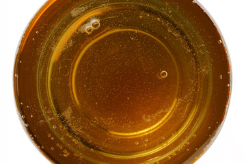 Light beer in a glass with foam and bubbles close-up, top view, isolated on white