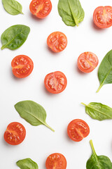 Beautiful border made of fresh cherry tomatoes with spinach leaves, Vegan diet food isolated on white, vegetable pattern, top view