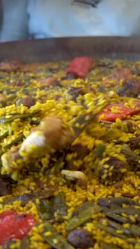  Slow moton, close up metallic spoon moving a valencian paella
