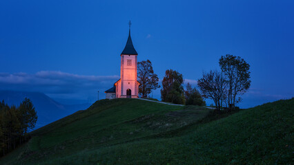 Jamnik church St Primus and Felician on the green hill at the dusk, Slovenia. Night alpine landscape, outdoor travel background