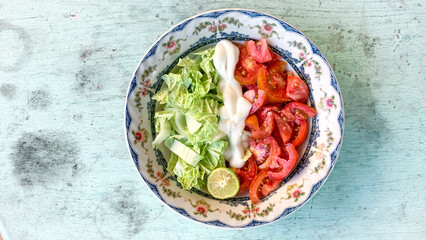 bowl of vegetable salad with chinese cabbage, tomato with mayonnaise dressing 