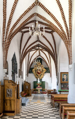 Aisle of St. John Evangelist church Kosciol Sw. Jana Ewangelisty in historic old town center of Bartoszyce in Poland