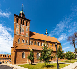 Naklejka premium St. John Evangelist church Kosciol Sw. Jana Ewangelisty aside Plac Konstutucji square in historic old town center of Bartoszyce in Poland