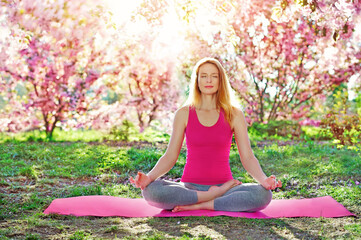 Sportive woman relaxing and meditating in the park