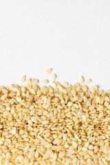Sesame seeds border isolated on white background. Raw sesame seeds close up and copy space