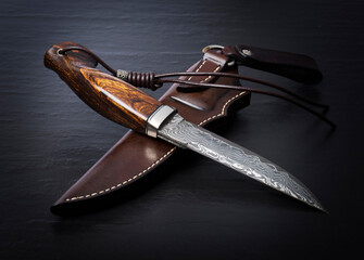 Hunting knife handmade on a black background.