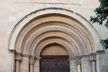 Fototapeta premium Decorated Romanesque flared arch and capitals with sculptures in the Romanesque church of San Millan in Segovia. Spain