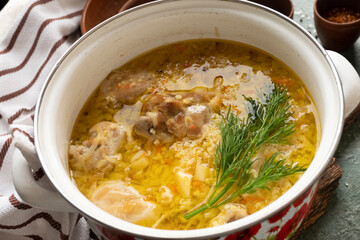 Thick soup with meat and cereals in a saucepan, close-up, home cooking