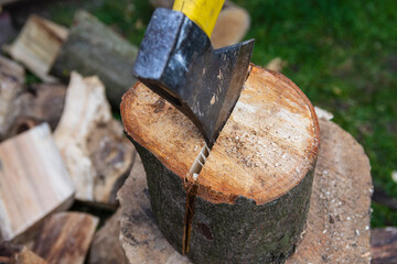 An ax and a stump while chopping firewood on a clear day. Heating.